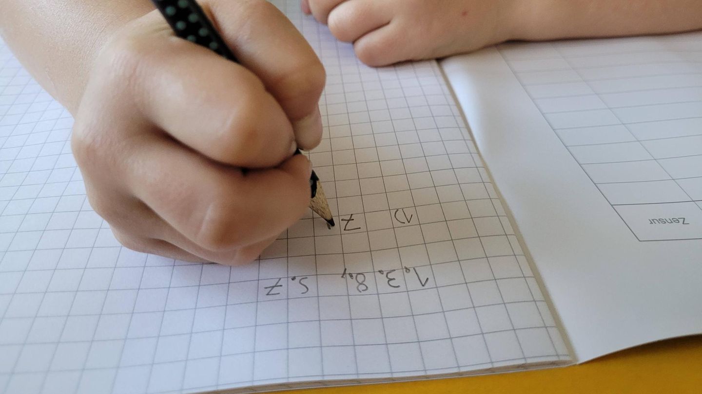 Schulabbruch: Eine Kinderhand schreibt Hausaufgaben in ein Schulheft Schulabbruch: Eine Kinderhand schreibt Hausaufgaben in ein Schulheft