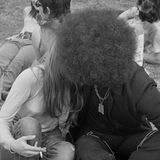 Ein Paar küsst sich, sitzend in einem Park.