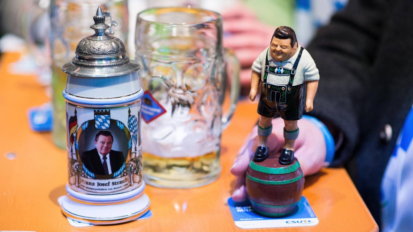 Auf dem Politischen Aschermittwoch sind eine Figur von Franz Josef Strauß und ein Bierkrug mit seinem Gesicht darauf zu sehen
