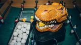 ein Brontosaurus-Kopf hält das Prontospray damit werden die Stangen eingesprüht, daneben eine Box mit Bällen