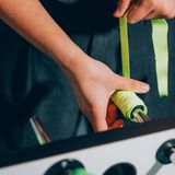 Hände die ein gelbes Grippband um den Griff wickeln