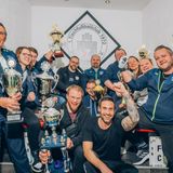 Eine Gruppe Männer und Frauen hält ihre Pokale in die Höhe