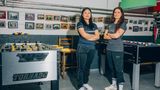 2 Frauen stehen die Arme verschränkt zwischen zwei Tischfußball-Tischen.