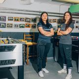 2 Frauen stehen die Arme verschränkt zwischen zwei Tischfußball-Tischen.