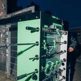 ein Tisch wird vertikal auf Rollen durch ein Gittertor geschoben