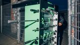 ein Tisch wird vertikal auf Rollen durch ein Gittertor geschoben