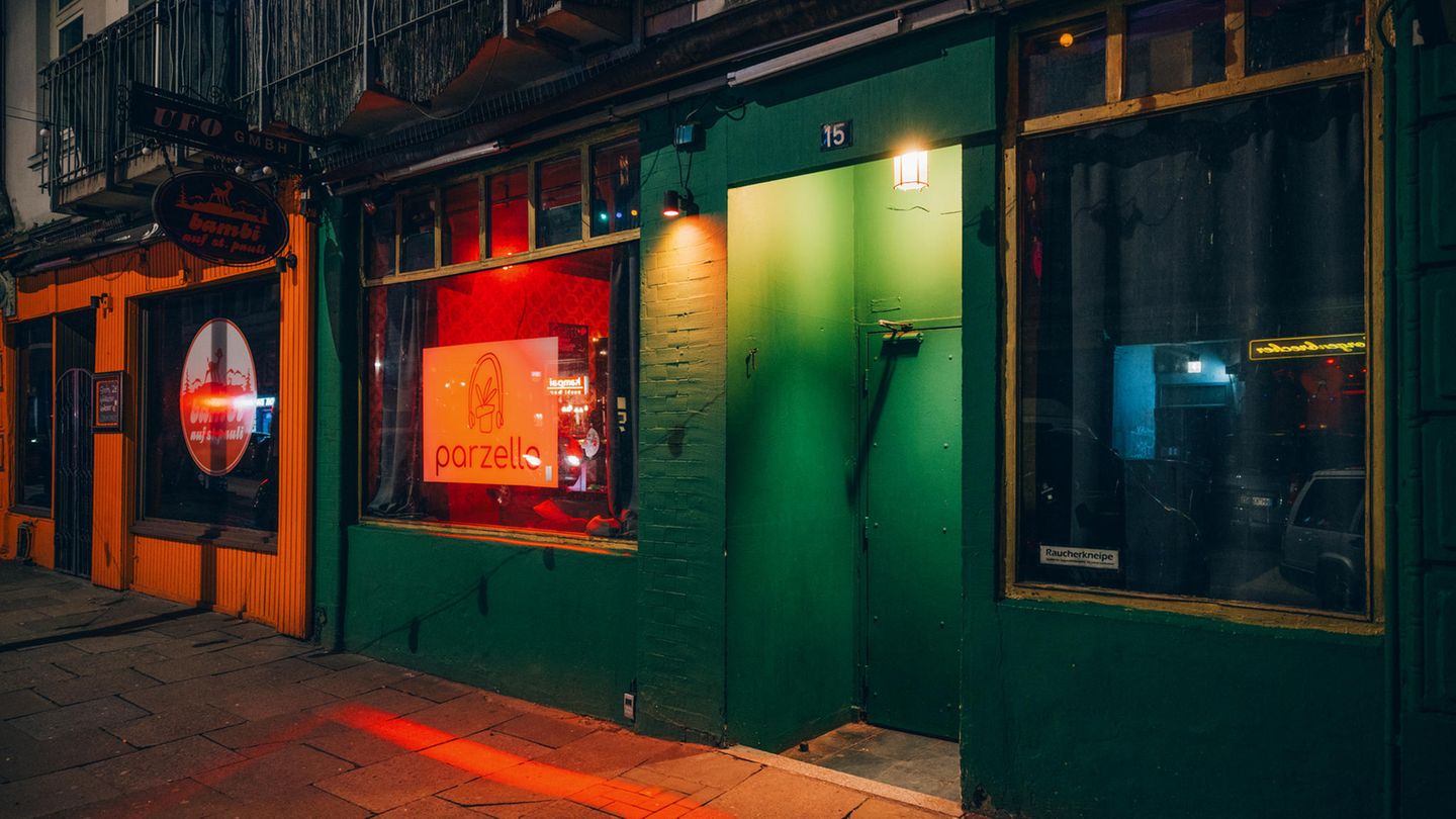 Es ist Nacht. Bunte Lichter leuchten aus den Scheiben der Bar