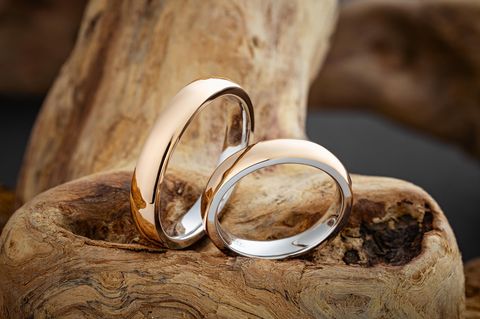 Glänzende gold Eheringe auf natürlichem Holzhintergrund