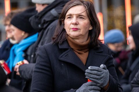 Katrin Göring-Eckardt trägt auf einer Kundgebung ein rotes Grablicht