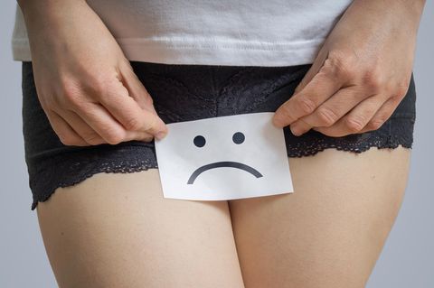 Frau mit traurigem Smiley im Schoß