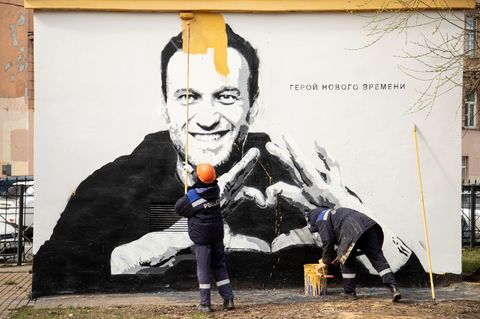 Städtische Arbeiter übermalen ein Graffiti mit dem Konterfei des russischen Oppositionellen Nawalny. Daneben steht "Held unserer Zeit" – für Putin-Gegner war Nawalnyj eine Leitfigur, für Regimeanhänger der ewige Störenfried, den es zu beseitigen galt.