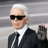 Karl Lagerfeld winkend, bekleidet im schwarzen Anzug