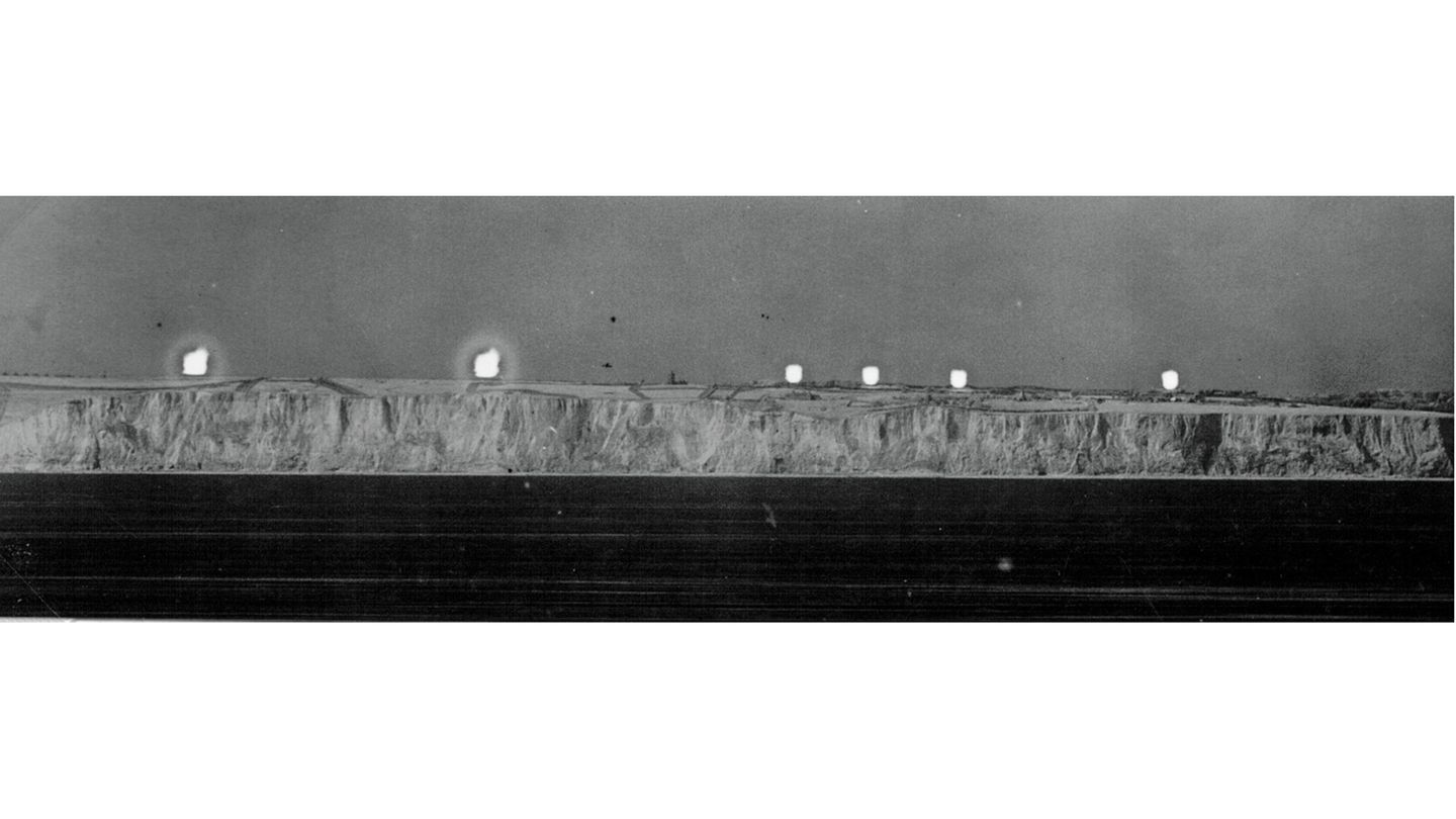 Nachtaufnahme mit einer Brennweite von drei Metern einer mehr als dreistündigen Belichtung der englischen Kanalküste: Englische Fernkampfbatterien beschießen am 13. August 1942 einen Geleitzug. Durch Kreuzpeilung lassen sich die Koordinaten der Geschütze ermitteln.