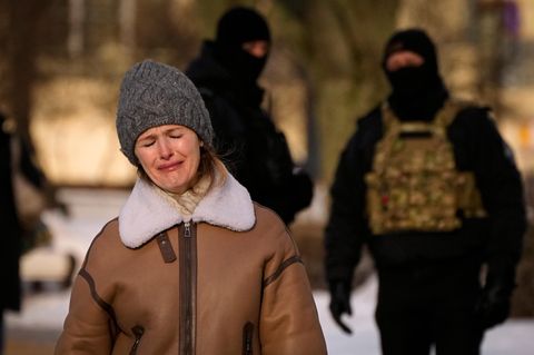 Polizisten beobachten eine weinende Frau, die dem verstorbenen Kremlgegner Alexej Nawalny gedenkt