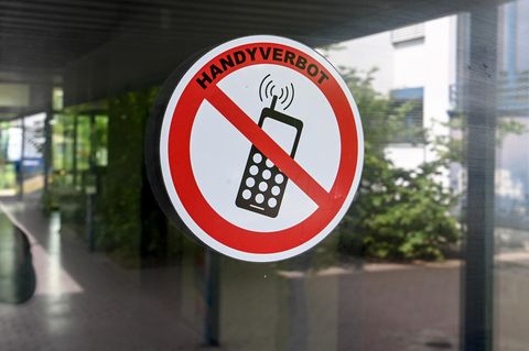 Ein Schild "Handyverbot" ist am Eingang einer deutschen Schule angebracht