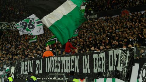 "Nein zu Investoren in der DFL" steht auf einem Plakat am Zaun vor den Fans von Hannover 96