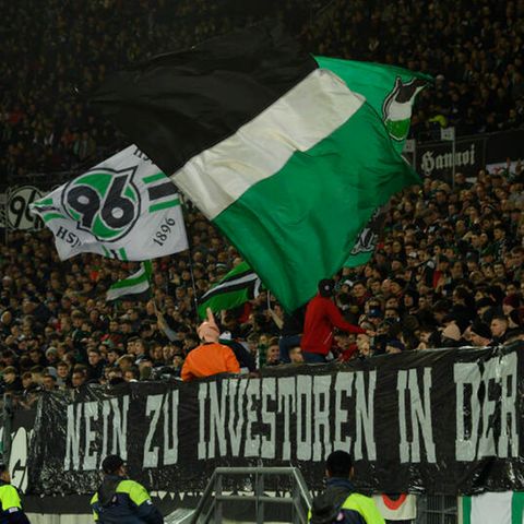 "Nein zu Investoren in der DFL" steht auf einem Plakat am Zaun vor den Fans von Hannover 96