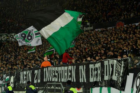 "Nein zu Investoren in der DFL" steht auf einem Plakat am Zaun vor den Fans von Hannover 96