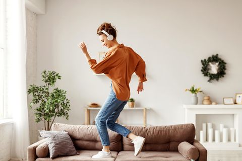 Glücksmoment: Frau tanzt durch die Wohnung