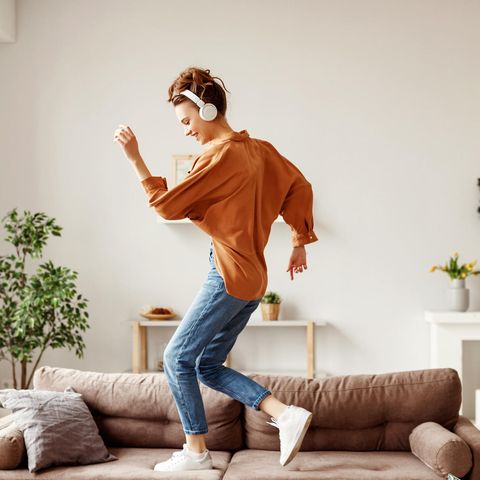 Glücksmoment: Frau tanzt durch die Wohnung