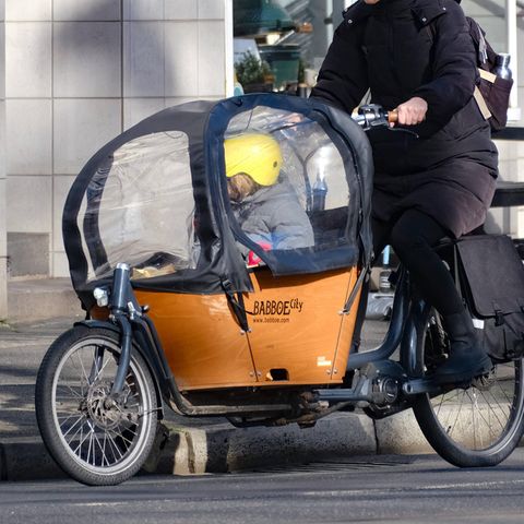 Frau fährt mit Kind auf einem Babboe-Lastenfahrrad