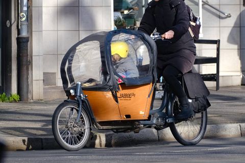 Frau fährt mit Kind auf einem Babboe-Lastenfahrrad