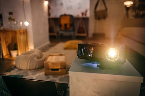 Wohnzimmer mit Projektor mit eingeschaltetem Licht für eine Show