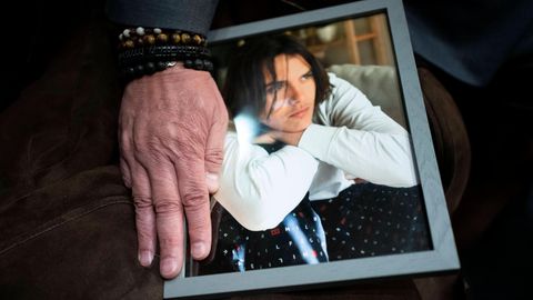 Ein Mann legt seine Hand auf das Foto seines Sohnes Daniel Puerta-Johnson, der an einer Fentanyl-Vergiftung gestorben ist