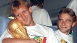 Schließlich hat Brehme die größte Trophäe des Fußballs für einem Moment ganz für sich allein. Thomas Häßler schaut lächelnd zu.