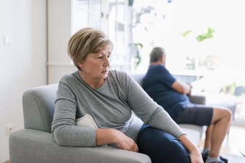 Scheidung: Ein getrenntes Ehepaar sitzt weit auseinander auf dem Sofa