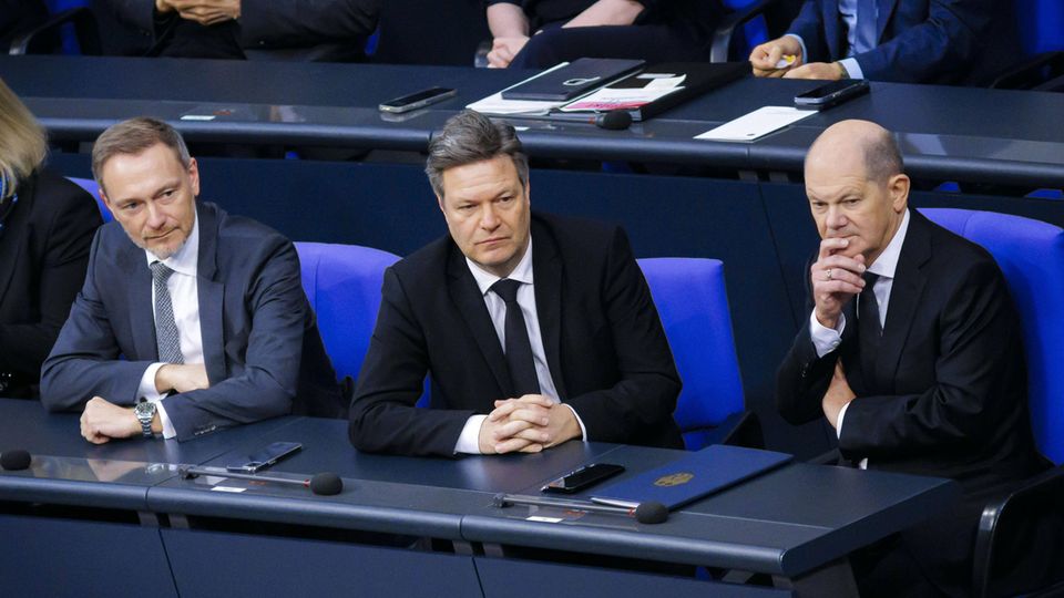 Männer der Ampel-Koalition: Lindner, Habeck und Scholz, drei Männer in Anzügen, sitzen auf den blauen Stühlen im Bundestag
