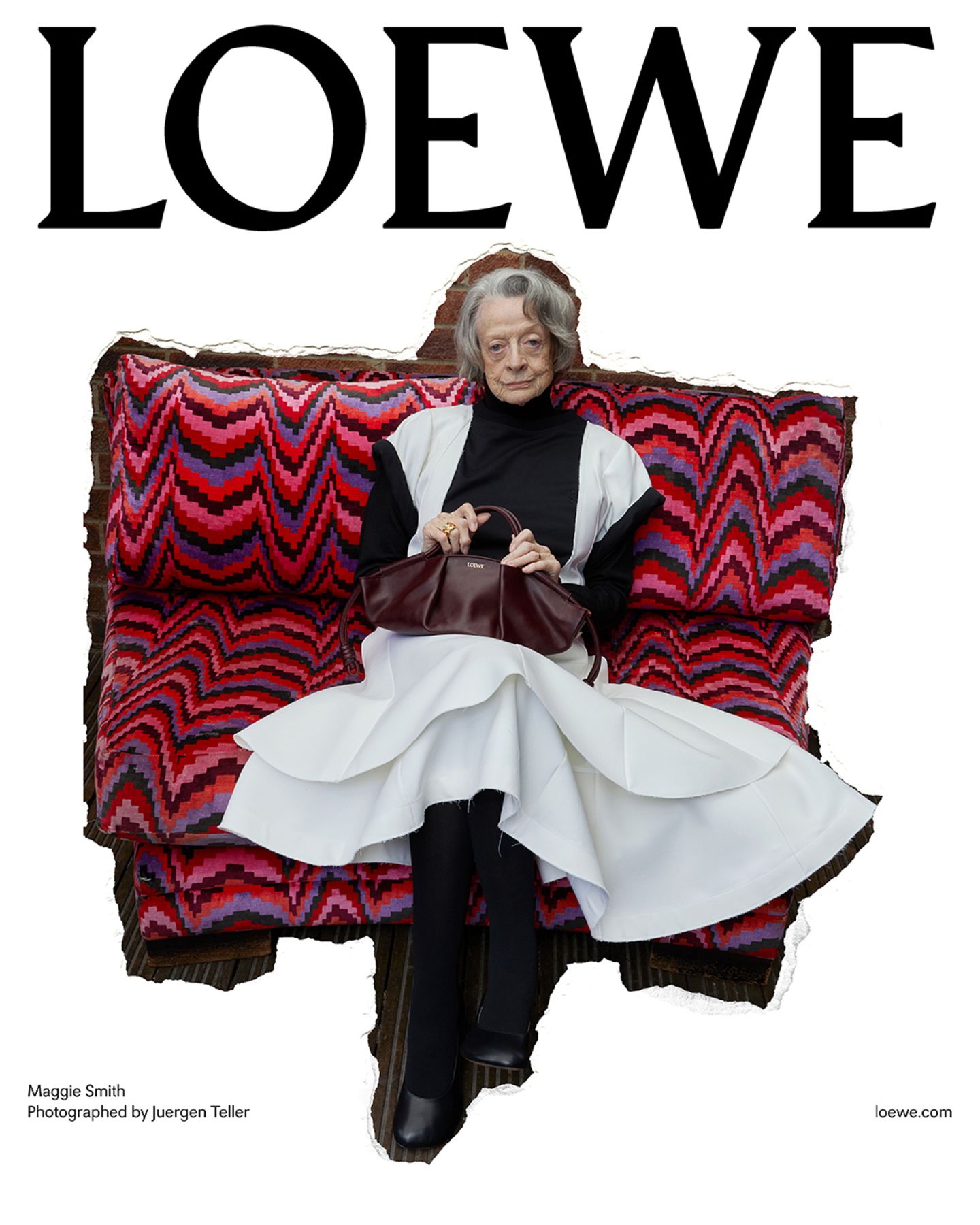 Schauspielerin Maggie Smith auf einem roten Sofa sitzend