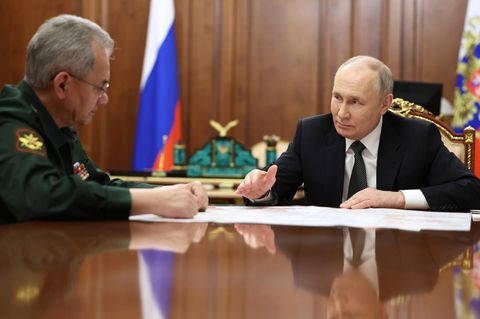Russlands Staatschef Wladimir Putin sitzt zusammen mit seinem Verteidigungsminister Sergej Schoigu im Kreml