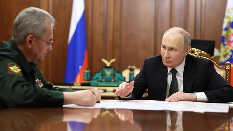 Russlands Staatschef Wladimir Putin sitzt zusammen mit seinem Verteidigungsminister Sergej Schoigu im Kreml
