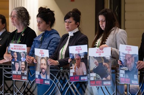 Angehörige zeigen während einer Rede des israelischen Präsidenten Izchak Herzog Plakate mit Fotos von Geiseln der Hamas