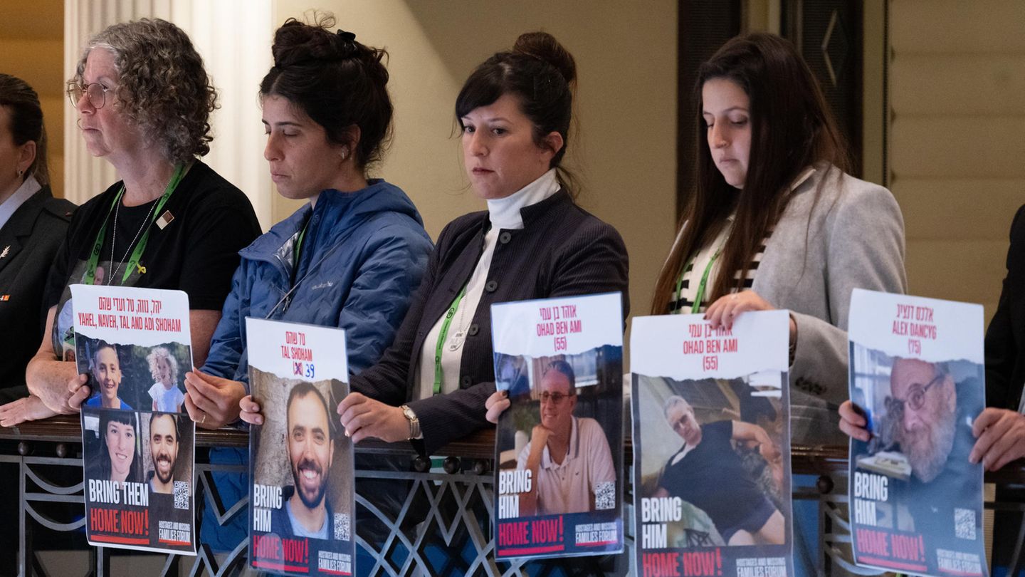Angehörige zeigen während einer Rede des israelischen Präsidenten Izchak Herzog Plakate mit Fotos von Geiseln der Hamas
