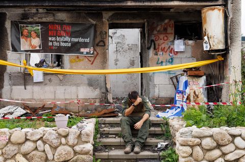 Ein Soldat besucht den zertörten Kibbuz Kfar Aza