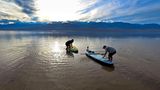 Es ist ein seltenes Vergnügen, das aktuell im Death Valley Nationalpark in den USA zu beobachten ist. Der eigentlich trockenste Ort der Vereinigten Staaten lockt dieser Tage vor allem jene Besucher an, die Freude am Wasser haben. Touristen kommen mit SUP-Boards, Kajaks und kleinen Booten oder wandern durch den kleinen See, der sich dort gebildet hat, wo eigentlich eine Wüste zu finden ist. Die Leitung des Nationalparks wirbt auf der Webseite sogar mit dem See und schreibt: "Ein vorübergehender See bietet eine seltene Gelegenheit zum Kajakfahren am trockensten Ort der Vereinigten Staaten". Grund für das beeindruckende Naturschauspiel sind die heftigen Niederschläge der vergangenen Wochen, die ganz Kalifornien trafen. Dadurch hat sich Wasser am tiefsten Punkt der Wüste gesammelt, das laut Parkleitung nun wohl bis etwa April dafür sorgt, dass aus dem trockenen Ort ein echter Hotspot für Wasserliebhaber geworden ist. 