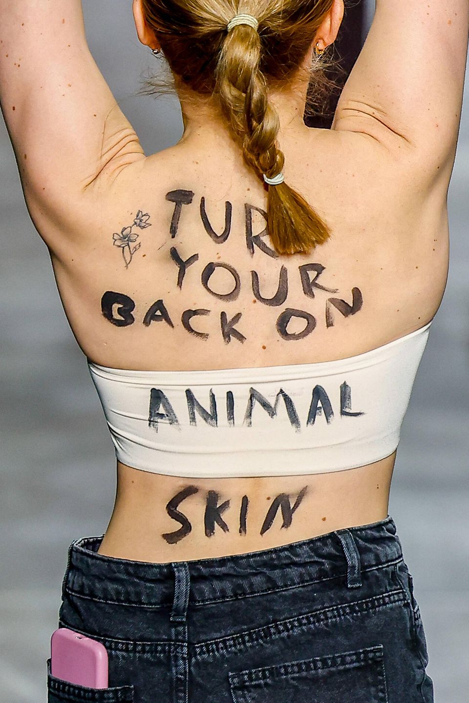 At Fashion Week in Milan: Back view of a PETA activist at the Fendi show At Fashion Week in Milan: Back view of a PETA activist at the Fendi show