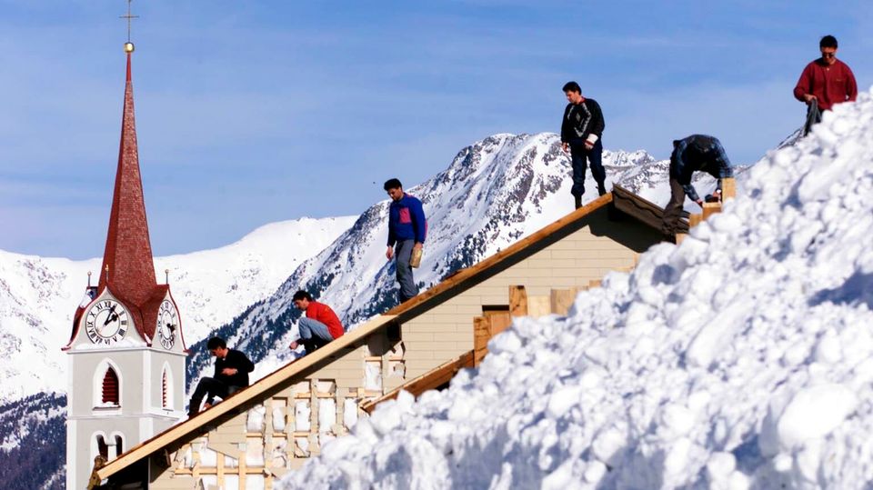 Lawinenunglück in Galtuer Helfer in Galtür stehen auf einem Dach und beginnen mit Aufräumarbeiten nach dem Lawinenunglück