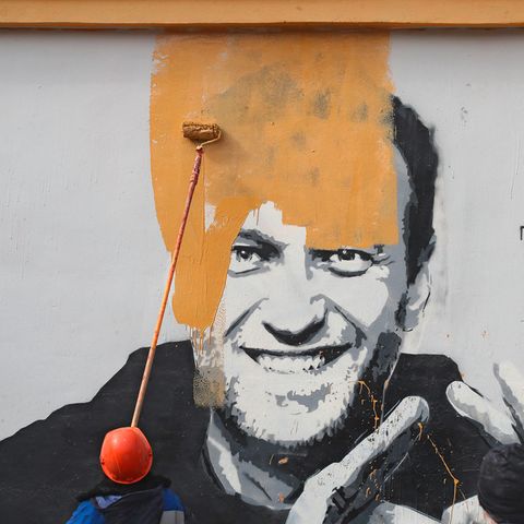 Ein Arbeiter überstreicht ein Mural von Alexej Nawalny in Sankt Petersburg, Russland