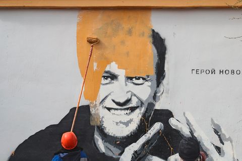 Ein Arbeiter überstreicht ein Mural von Alexej Nawalny in Sankt Petersburg, Russland