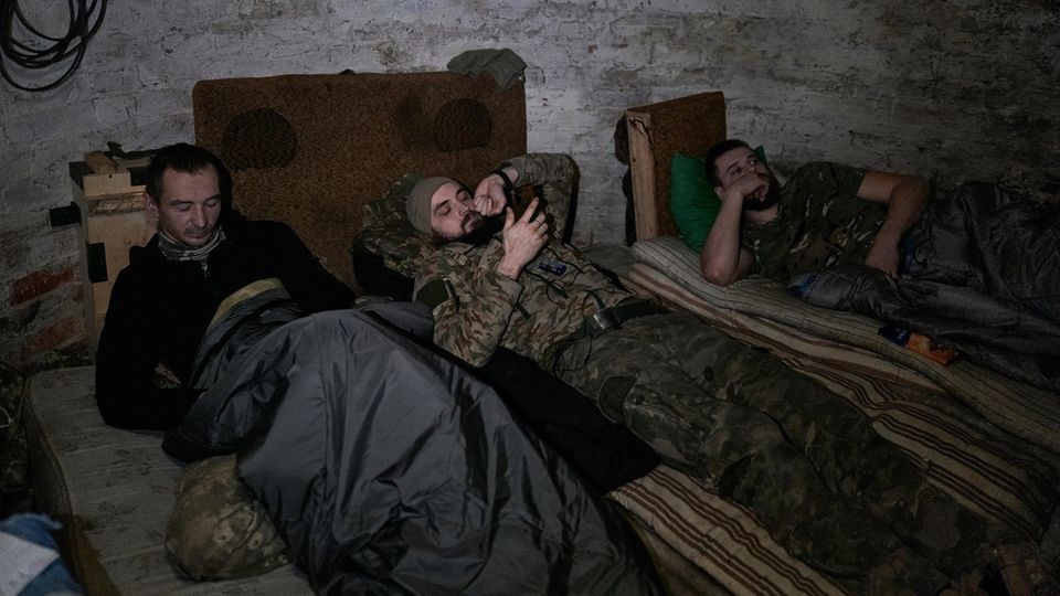 Müde Soldaten der Edelweiß-Brigade legen auf ihren Feldbetten eine Kampfpause an der Frontlinie bei Kupiansk ein