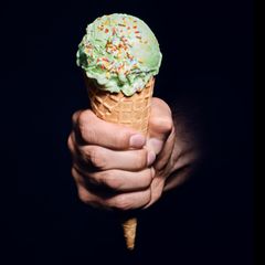 Eine Männerhand hält eine Eistüte