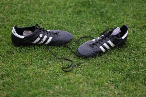 In der Kreisliga liegen einfache Fußball-Schuhe auf dem Rasen