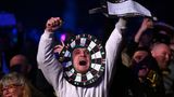 Darts-Fan trägt als Kostüm eine Darts-Scheibe um den Kopf