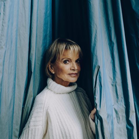 Hier schaut Uschi Glas zwischen einem Vorhang hindurch