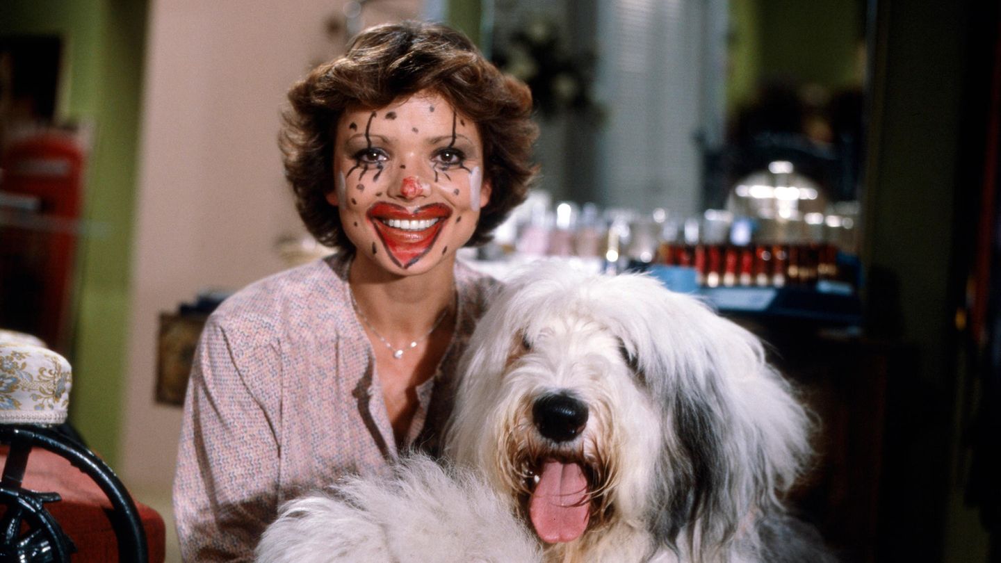 Uschi Glas mit einem Hund, ihr Gesicht ist geschminkt wie ein Clown