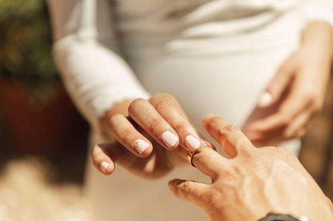 Ein Paar tauscht Ringe als Symbolfoto für Date mit vergebenem Mann