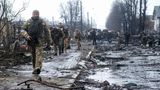Ukrainische Soldaten inspizieren die Trümmer einer zerstörten russischen Panzerkolonne auf einer Straße in Butscha